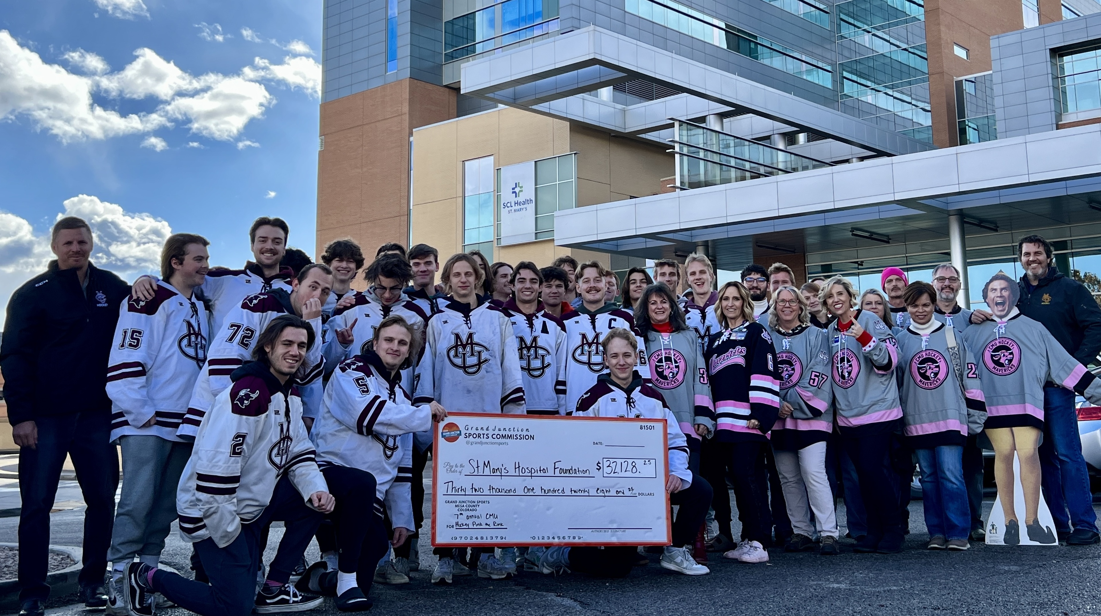 cmu-hockey-team-and-coach-with-donation-check.jpg